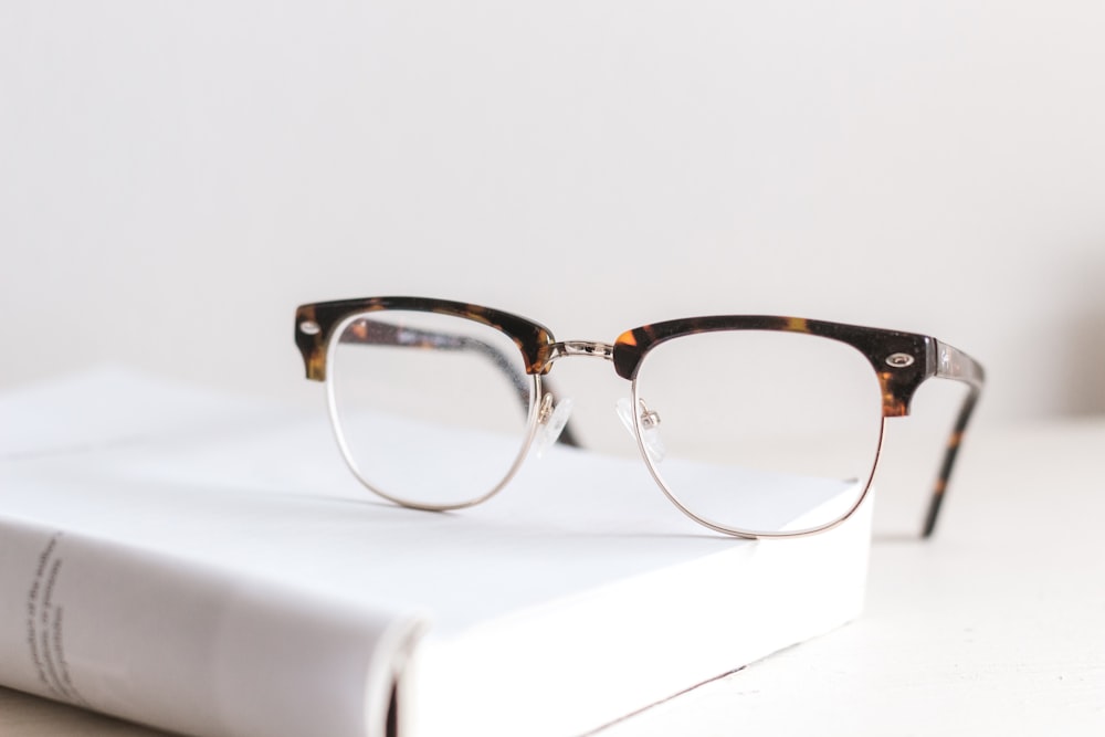 Designer eyeglass frames displayed on a light surface